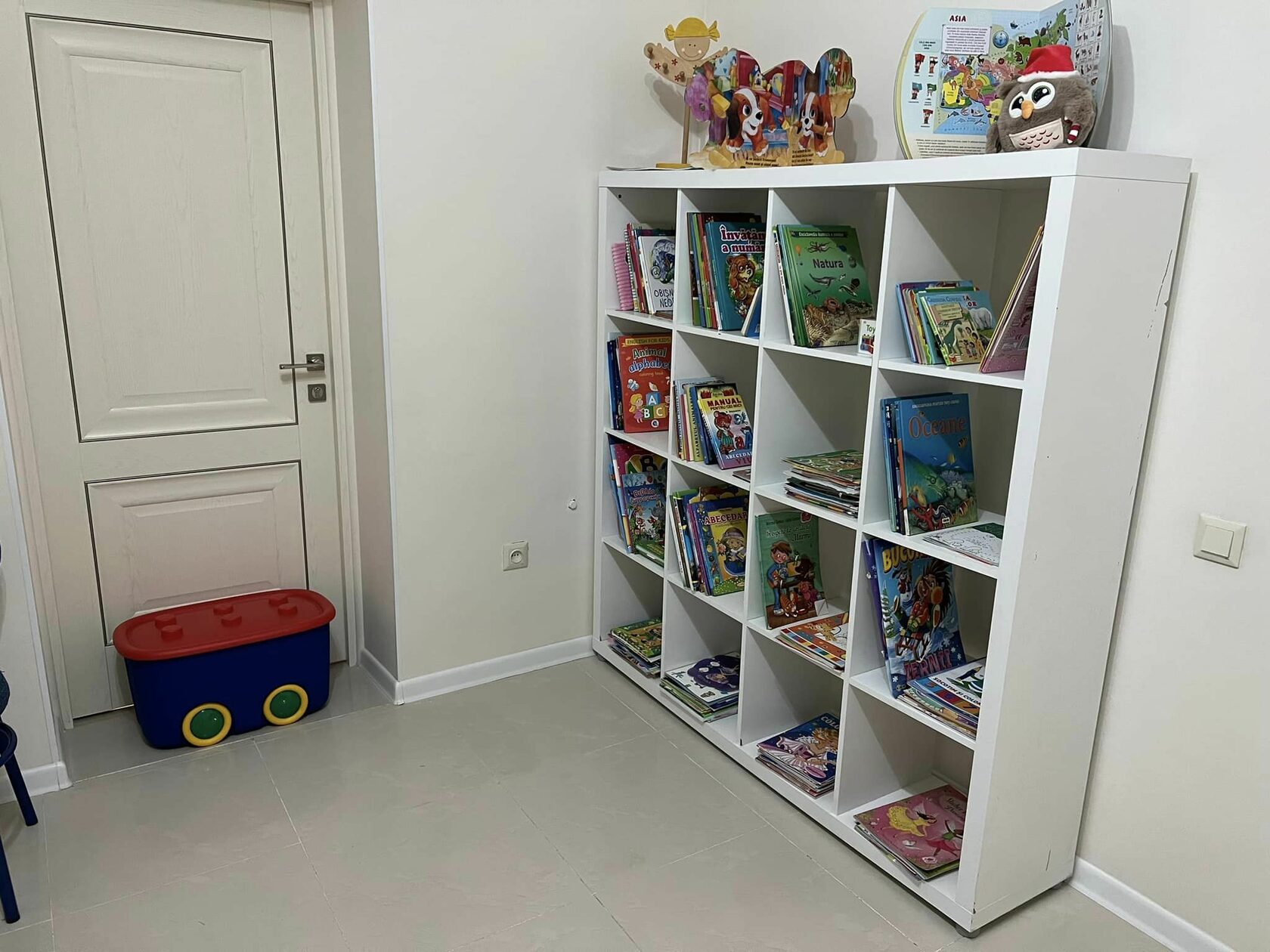 Zona de joacă pentru copii, cu raft plin de jucării și cărți